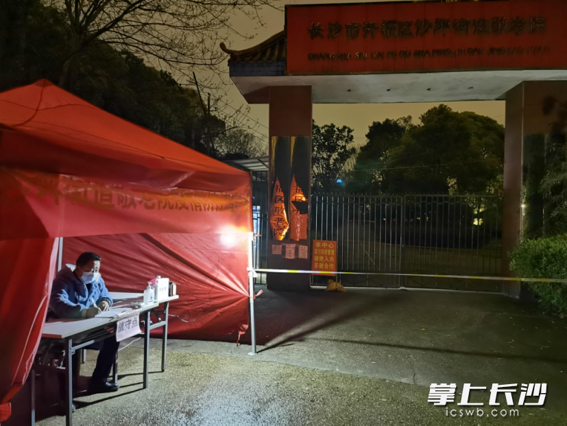 沙坪敬老院院长罗安心深夜在院门口进行疫情防控值守。