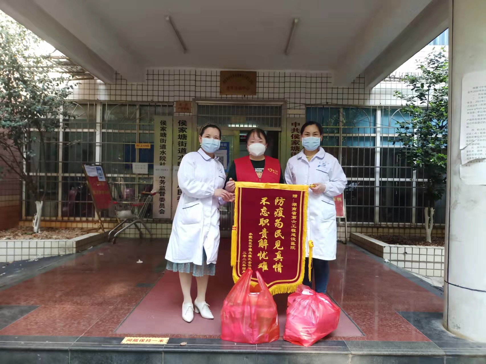 水院社区党总支书记胡惠将居民送来的锦旗转交给湖南省第六工程建设医院。均为水院社区供图 水院社区党总支书记胡惠将居民送来的锦旗转交给湖南省第六工程建设医院。均为水院社区供图