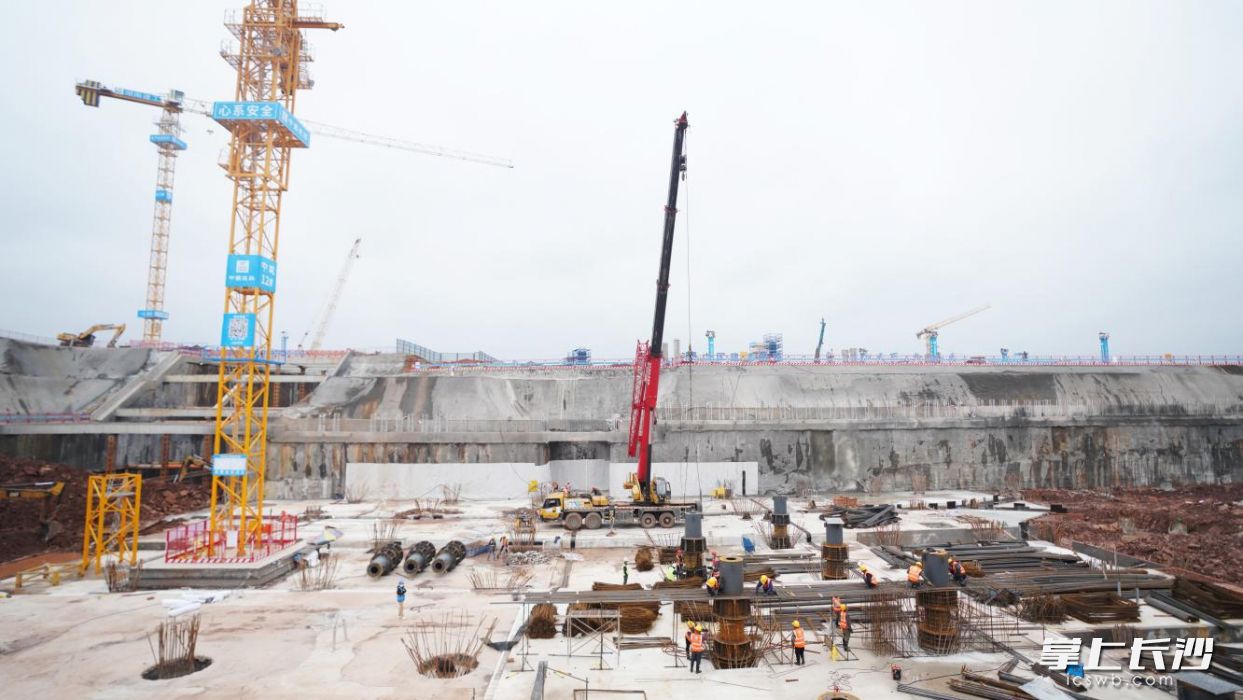 由中建五局牵头承建的长沙机场改扩建工程综合交通枢纽工程现场一派热火朝天的施工场景。