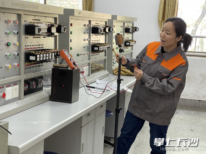 张剑录制网课“电器故障检修操作”时便请来丈夫欧阳陵江帮忙。图为欧阳陵江为张剑拍的录课照片。均为长沙晚报通讯员 王露曼 供图