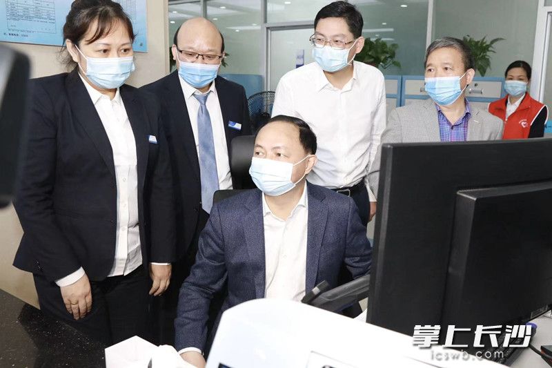 郑建新以窗口工作人员身份面对面接待办事群众，并通过数据后台审批申请资料。