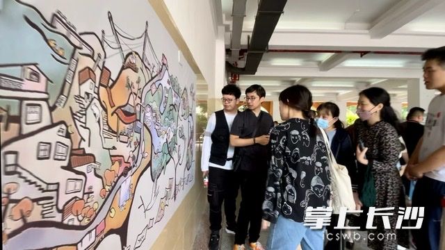进校办理手续的家长围观画展。