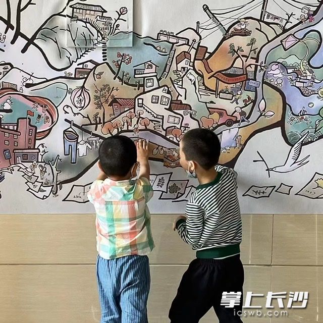 两个小男生在仔细研究插画细节。