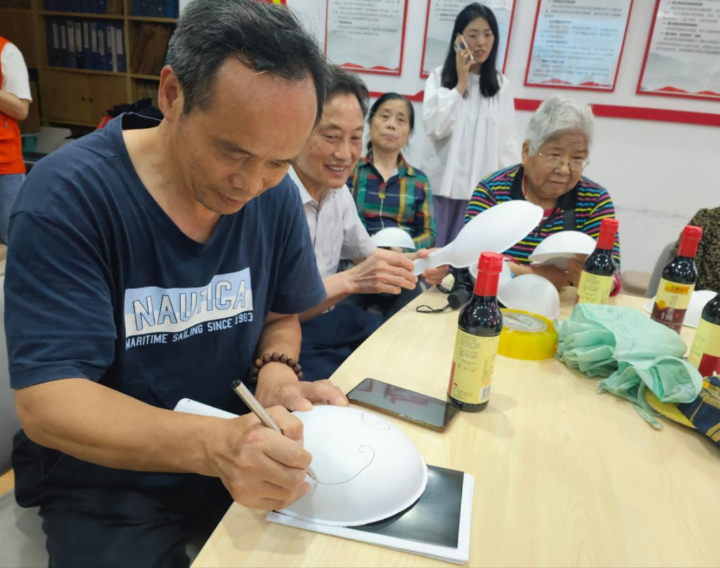 一笔一划，居民们认真地绘制京剧脸谱。