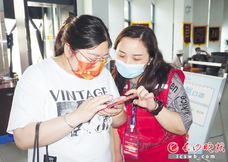 “芙蓉先锋帮代办”学员教市民办理手续。长沙晚报通讯员 杨宁 摄