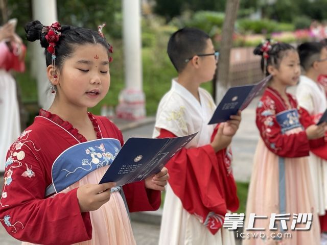 身着汉服的小女生认真地诵读着。