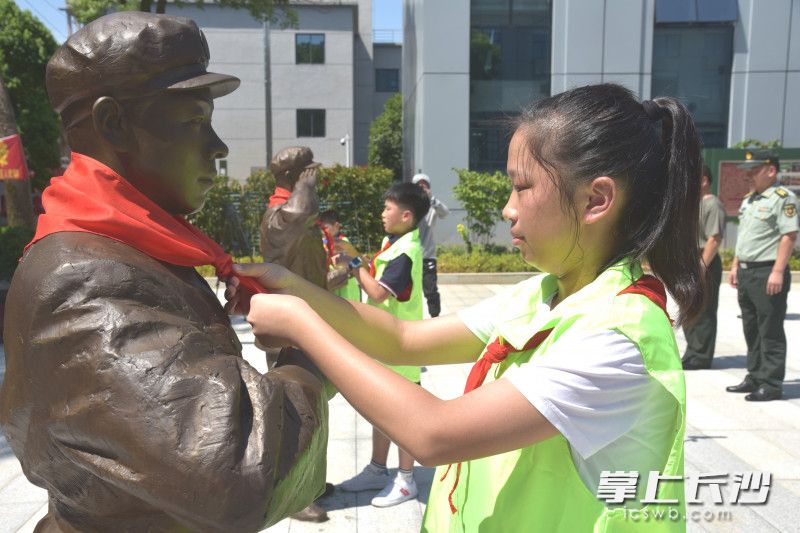 少先队员给雷锋铜像系上红领巾。   长沙晚报全媒体记者 贺文兵 通讯员 刘彬 摄