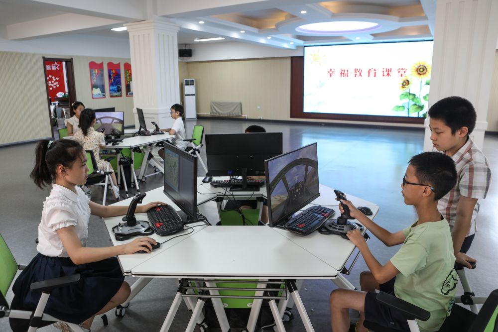 ↑8月18日，孩子们在牡丹社区群众活动中心学习固定翼模拟飞行课程。