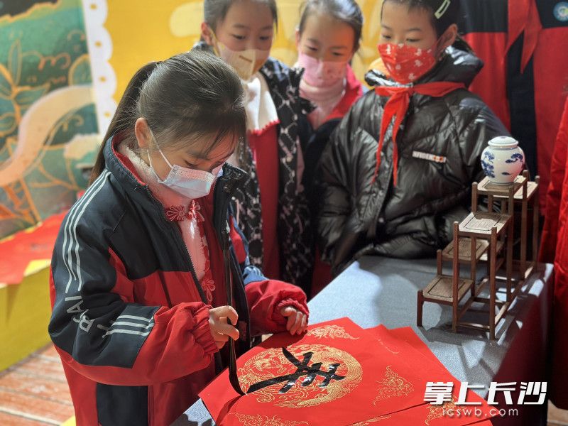孩子们写“春”字、剪窗花、折春纸。