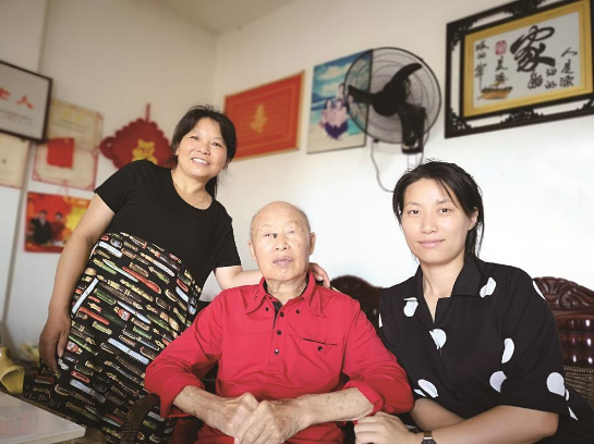 ▲黄枚生老人（中）带动家人累计捐资3000万元助力家乡建设。（资料图片）