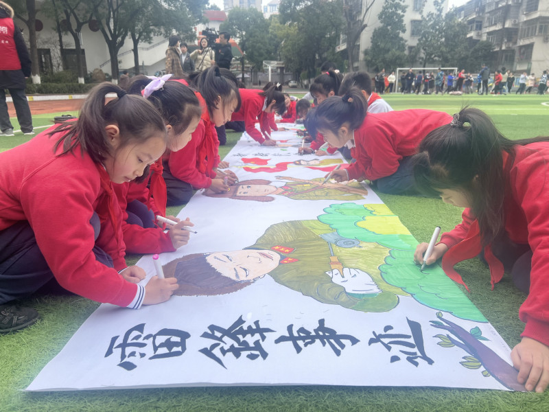 芙蓉区育才学校的操场上，孩子们在10米长卷上绘下奉献故事，感受雷锋精神的传承。长沙晚报通讯员冯适摄