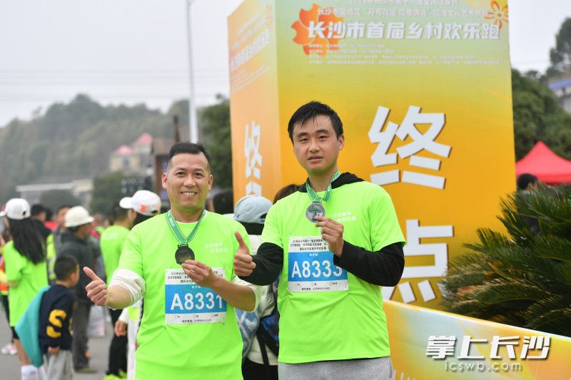 参赛选手完赛后向镜头展示奖牌。