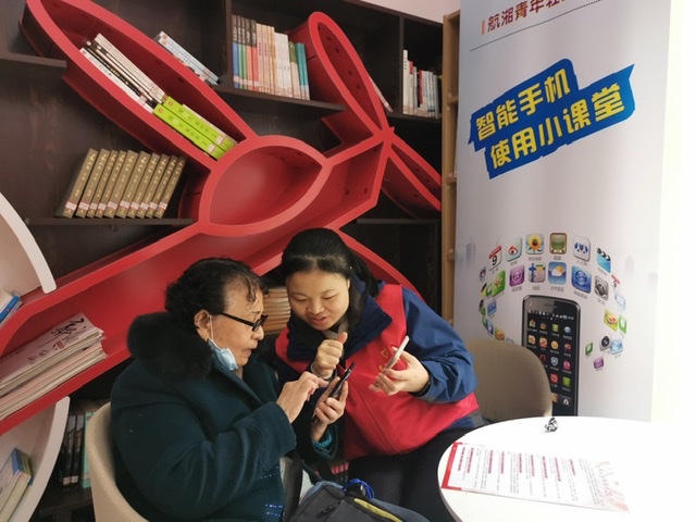 居民代表正在教老人使用智能手机。均为通讯员 杨青 供图