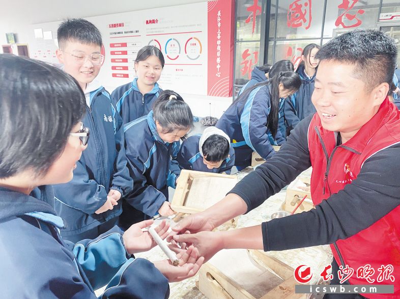 4月6日，南雅湘江中学的学生们在“中国好人”汤俊杰（右1）带领下现场体验艾条加工，助力助残扶贫。长沙晚报通讯员 冯千鑫 摄