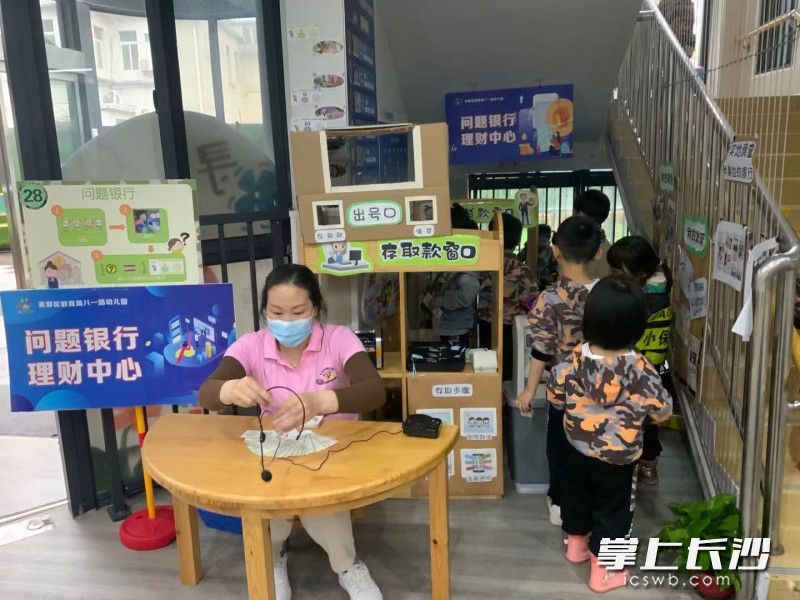 小朋友排队在“银行”存钱。 小朋友排队在“银行”存钱。