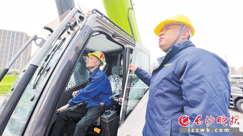 龙卫国（右）现场指导起重设备调试。长沙晚报全媒体记者 周辉霞 摄