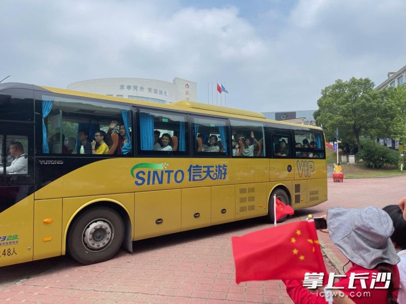 考生们也像欢送人群挥手致意。