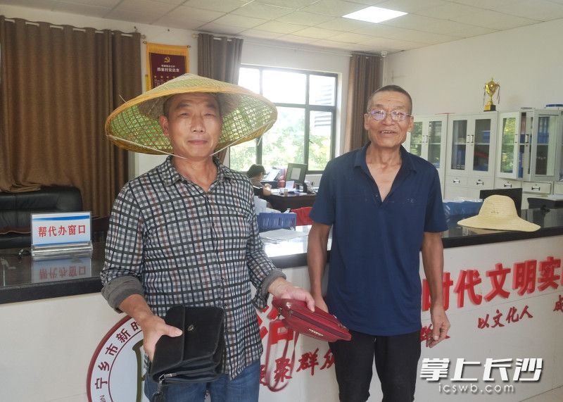 面对失而复得的12000多元，唐建军（左）不停地感谢着拾金不昧的保洁员黄本喜（右）。通讯员 钟俊夫 摄