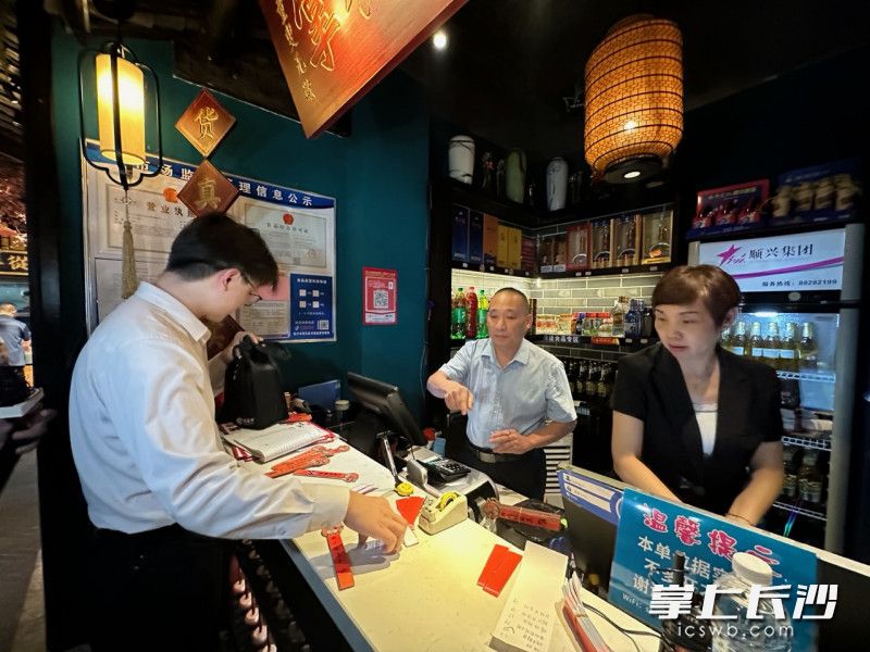 王先生（左）来到店内取回了现金。