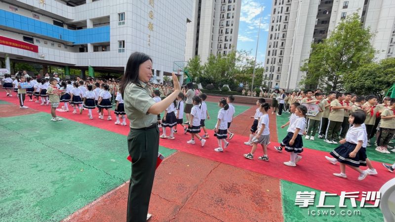 校长杨娜跟每一个走过成长门的小一新生打招呼问好。