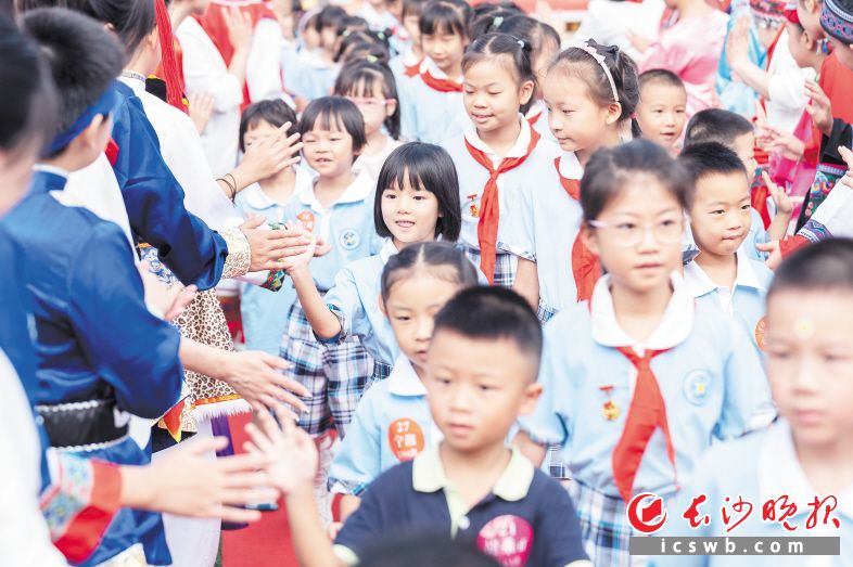 开学第一天，大哥哥大姐姐和新进校的小学弟学妹击掌表示欢迎。 长沙晚报全媒体记者 周数邑 摄