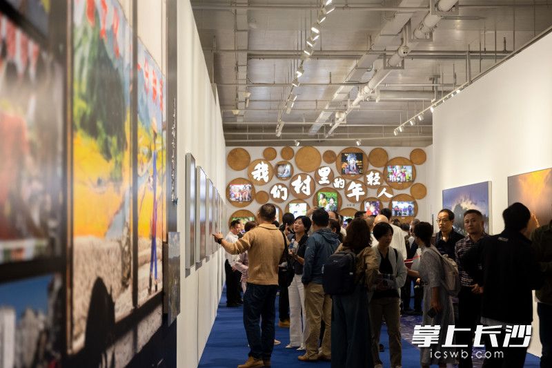 市民参观“洞见”乡村振兴——十八洞村的美丽蝶变主题摄影展。谢子龙影像艺术馆供图
