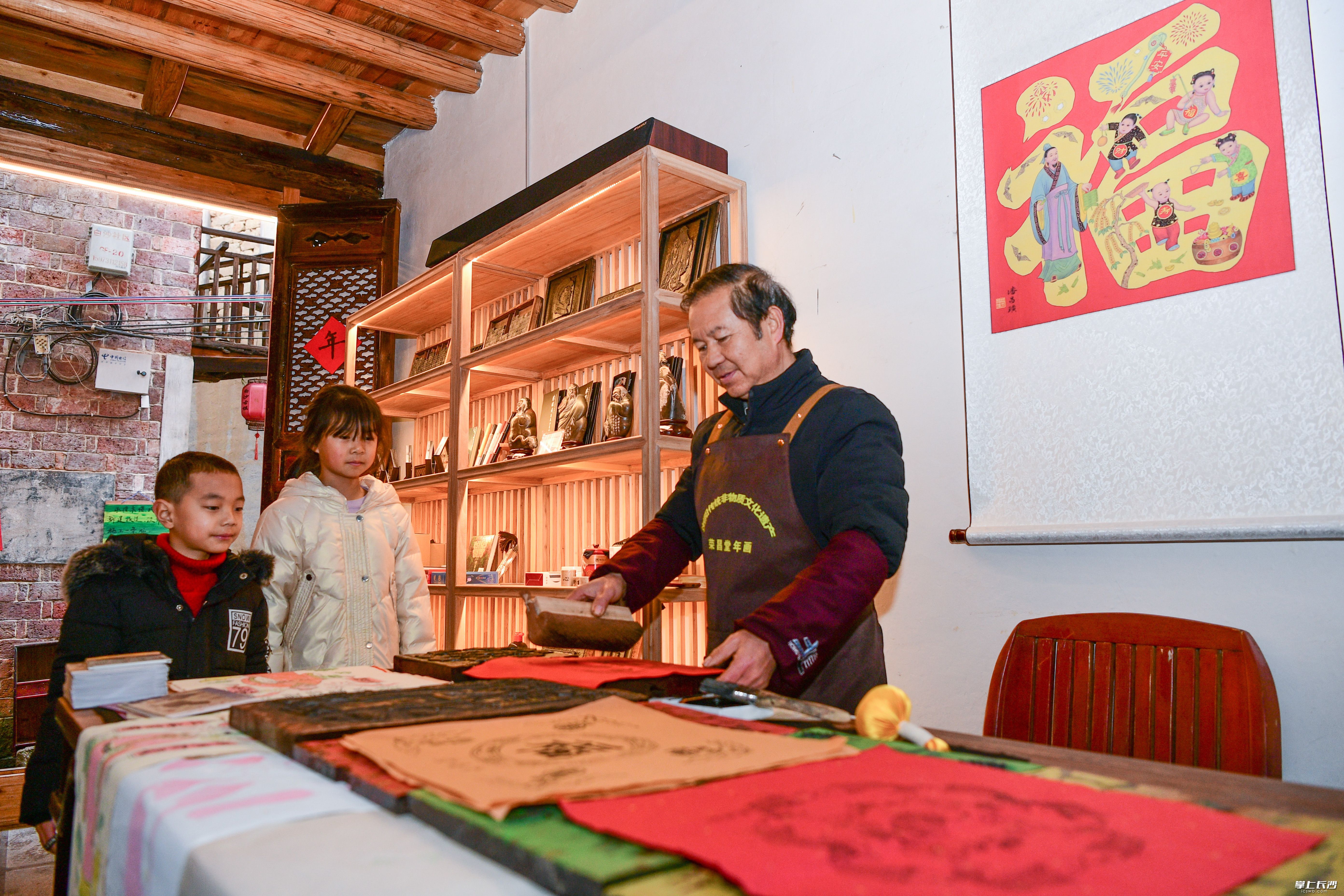 非遗市集里，当地非遗传承人展示木版年画技艺。彭红霞摄