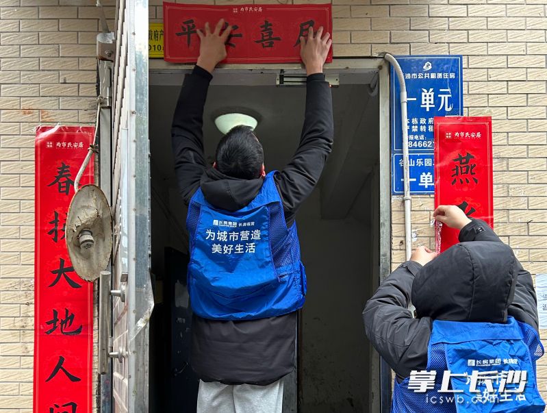 工作人员正在公租房小区张贴春联。 工作人员正在公租房小区张贴春联。