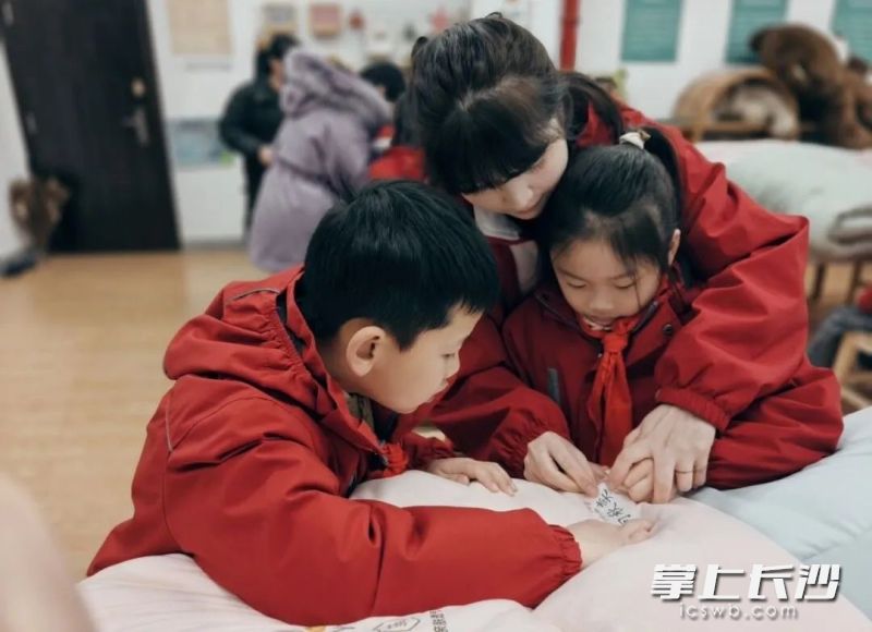 砂子塘小学老师在劳动课上指导学生缝姓名牌。  长沙晚报通讯员 曾小梅 摄