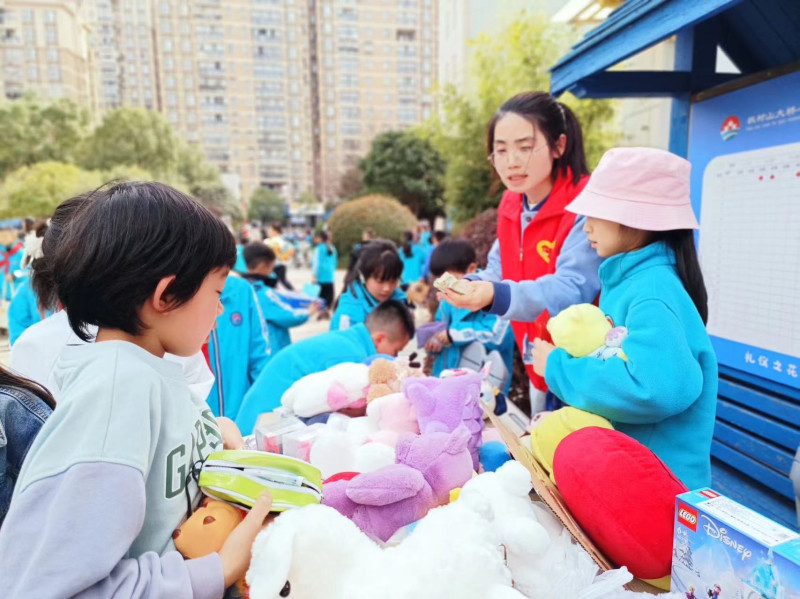 在枫树山大桥小学举行的雨花区2024年“德润雨花志愿红”学雷锋志愿服务爱心集市。均为长沙晚报通讯员 姚思远 摄