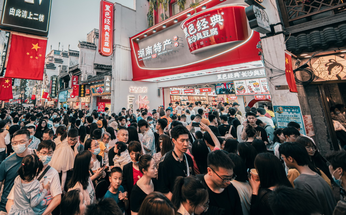 Crowds throng a Hey Hey Black stinky tofu store on Huangxing South Road in Changsha, Hunan province, in May 2023. (Photo/China Daily)
