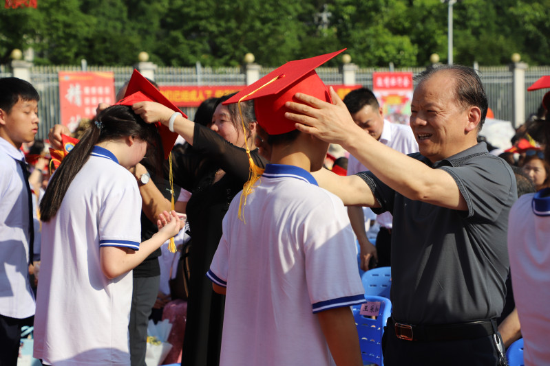 金海教育集团董事长杨建新给学生戴成人帽。