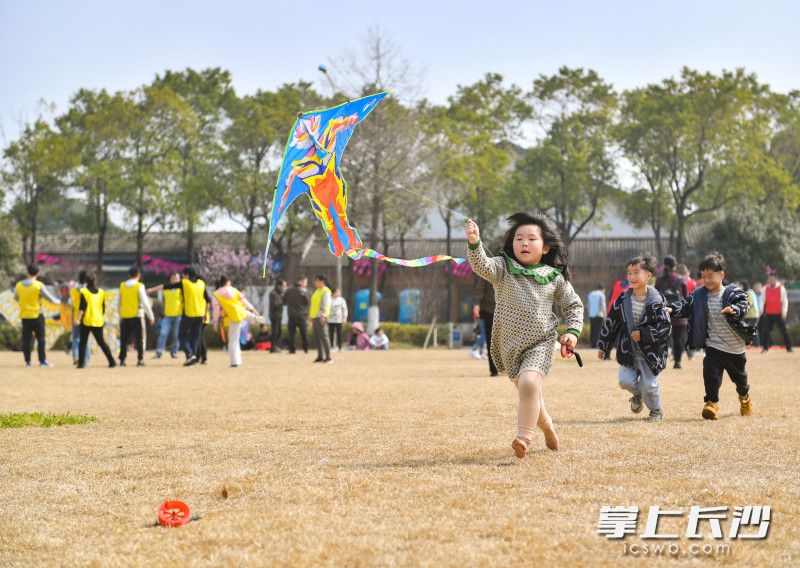 Children run free and fly kites on the lawn by Qianlong Lake, Wangcheng District. (Photo/Zou Lin)