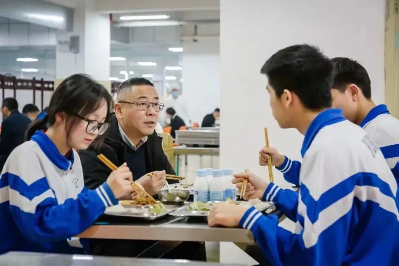 学校推行陪餐制，保证食堂饮食质量。图为长沙市实验中学党委书记肖建军（左二）跟学生一起进餐。资料图片