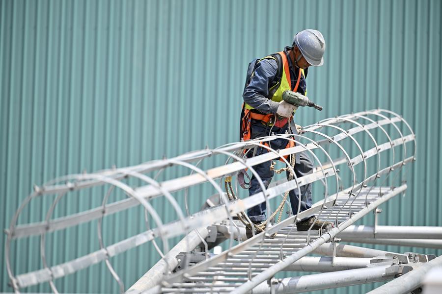 A staff member of the Ningxia branch of State Grid Corporation of China works at the construction site of the Zhongning converter station in northwest China's Ningxia Hui Autonomous Region, July 10, 2024. (Xinhua/Wang Peng)
