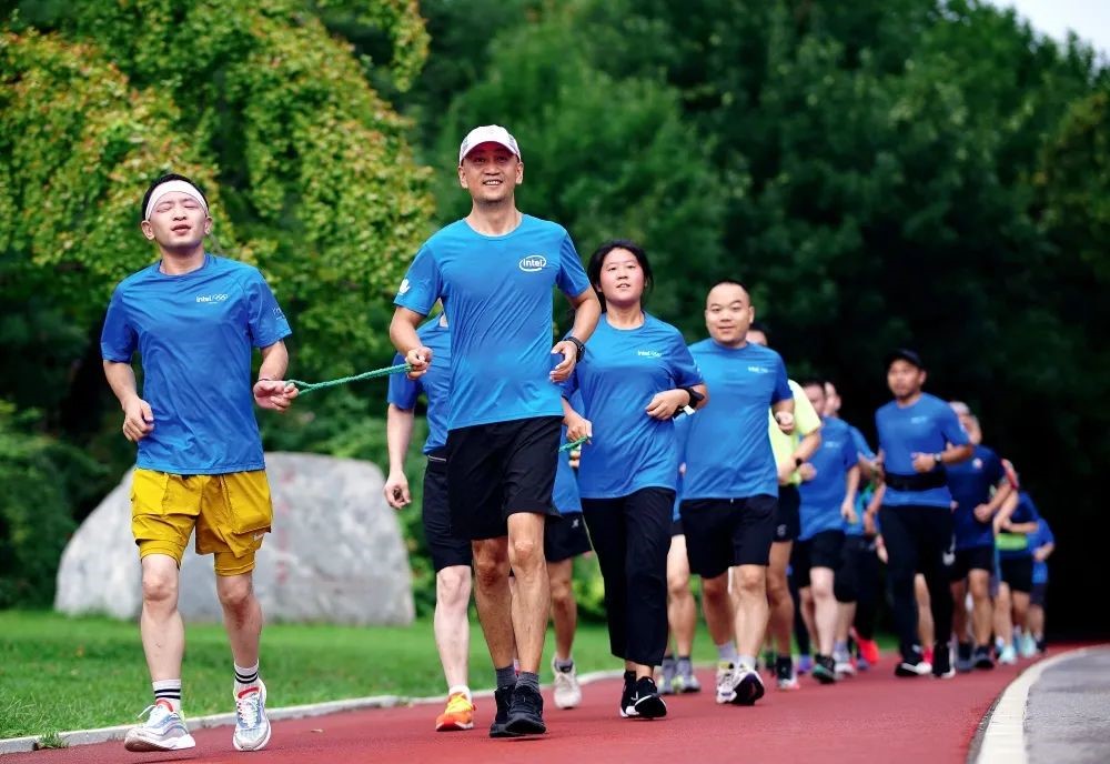 Individuals with visual impairment run at the Beijing Olympic Forest Park, guided by volunteers. (Photo/Zhang Ximeng)