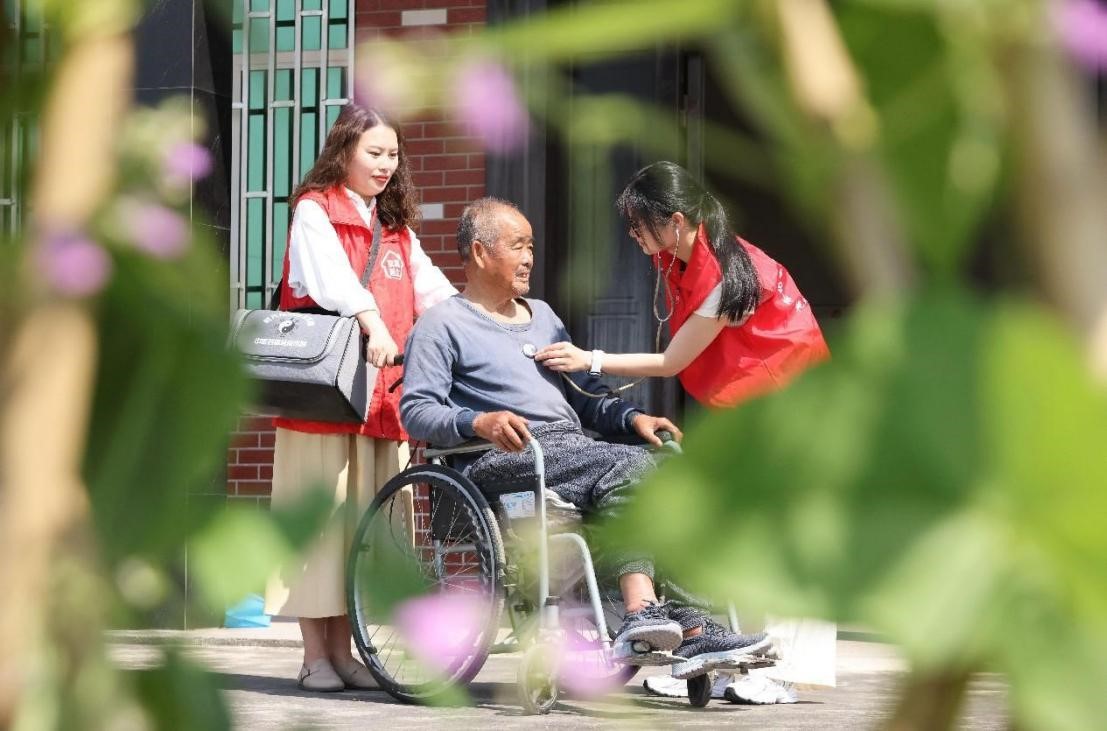 A doctor pays a home visit to a senior with mobility problem in Mingxing village, Deqing county, Huzhou, east China's Zhejiang province. (People's Daily Online/Ni Lifang)