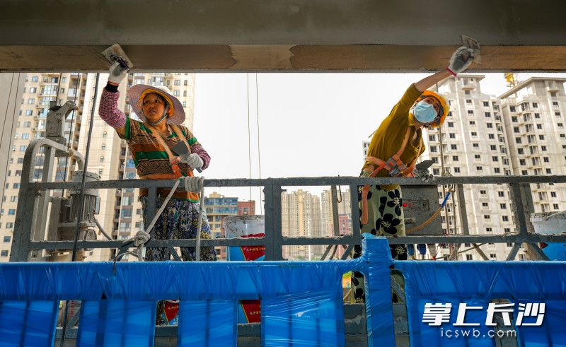 7月11日，在望城区月亮岛街道国欣云境府项目工地上，两位来自四川的外墙粉刷女工高温下高空粉刷外墙。长沙晚报全媒体记者 邹麟 摄