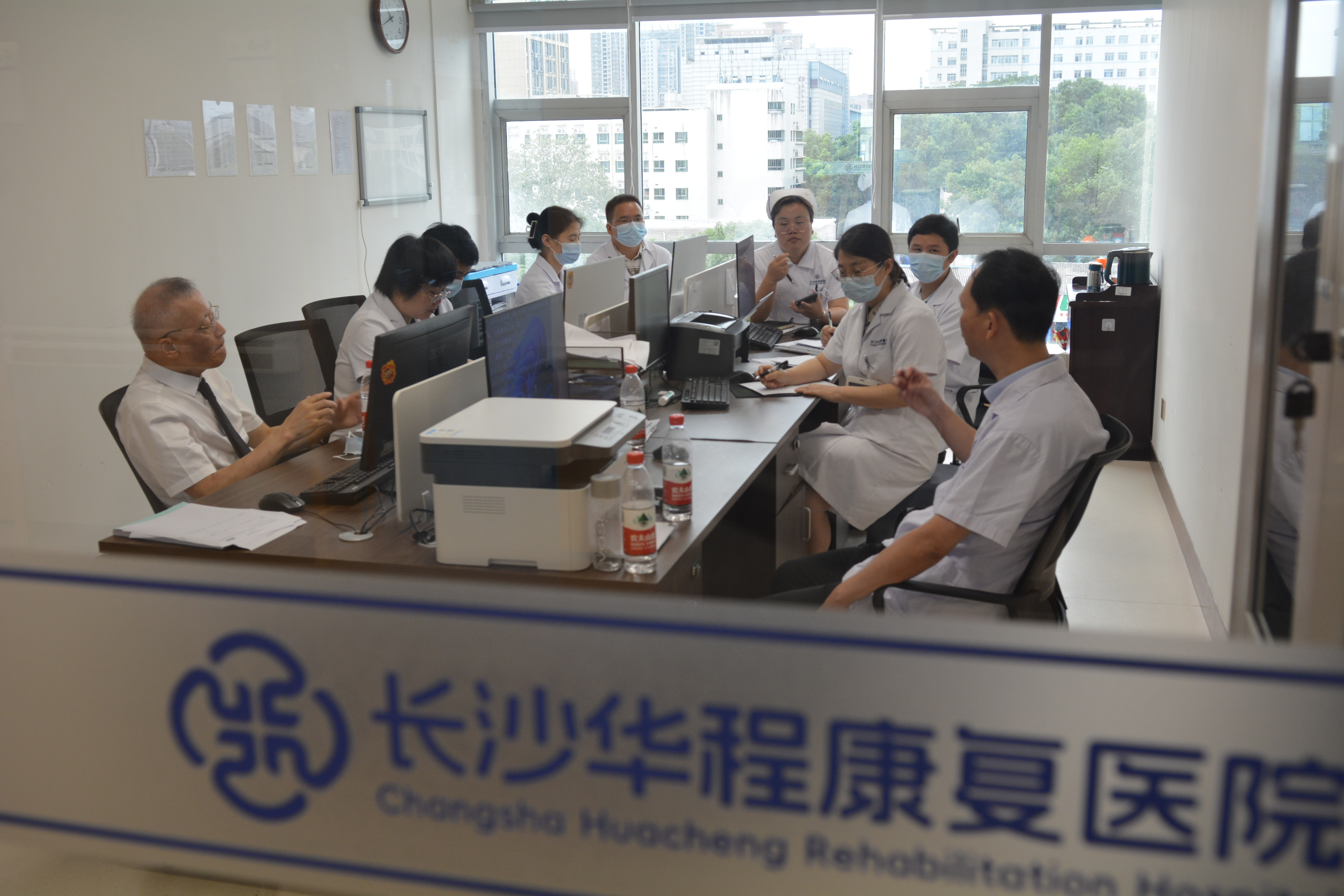 湖南省人民医院呼吸与危重症医学科RICU李建民主任与华程康复医院医护团队在进行病例讨论。