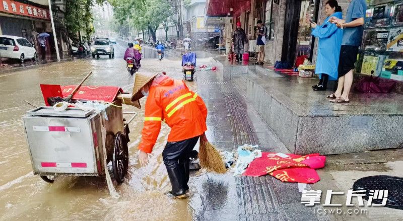 处理路面积水。长沙晚报通讯员 向薇 供图