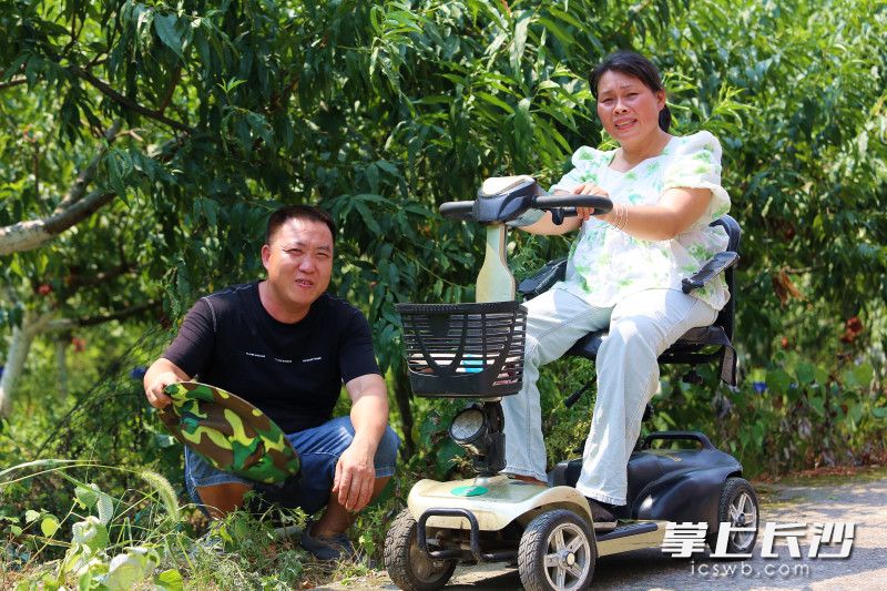 蒋千武将唐铃抱上车，去桃园摘桃。均为长沙晚报全媒体记者 贺文兵 摄