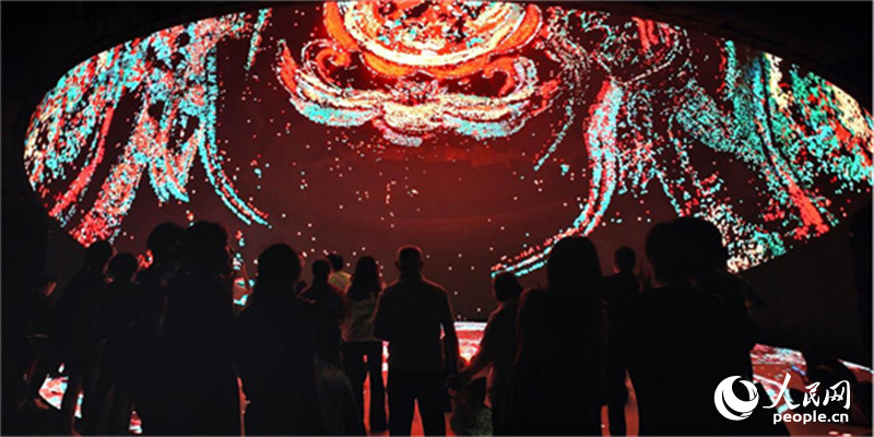 Visitors stand under a giant LED dome at Hunan Museum in Changsha, central China’s Hunan Province. (People’s Daily Online/Liu Wei)