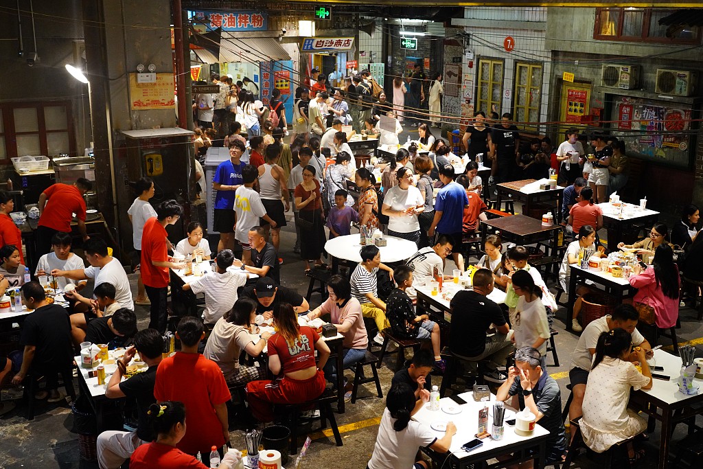 People enjoying food at a commercial street in Changsha, Hunan province, Aug 2, 2024. [Photo/VCG]