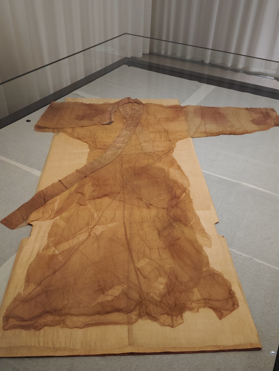 The plain unlined gauze gown with curved hem on display (Photo: China News Service/Ren Siyu)