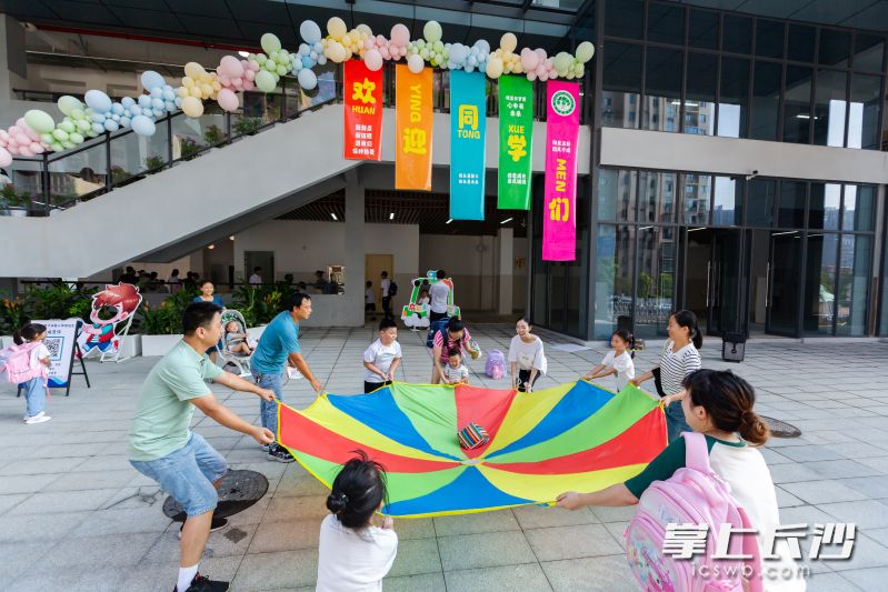 博才卓越小学西校区学生和家长玩转“彩虹伞”。均为长沙晚报通讯员 柳静静 供图