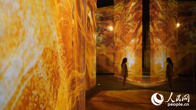 A tourist watches a digital replica of an artifact from the Mawangdui Tombs of the Han Dynasty (206 B.C. - 220 A.D.) at the Hunan Museum in Changsha, capital city of central China's Hunan Province. (People's Daily Online/Wu Xiwei)