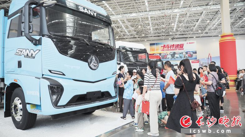 游客在讲解员带领下参观三一智联产业园，了解卡车制造过程。