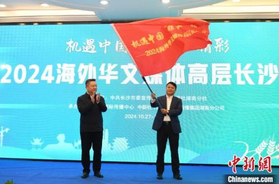 Chen Peng (left), Standing Committee member and Publicity Department director of the CPC Changsha Municipal Committee, presents a flag to Ma Qiang (right), president of China Weekly, a Chinese-Arabic bilingual newspaper registered in Egypt. Ma received the flag on behalf of the overseas Chinese media delegation. (Photo/Yang Huafeng)