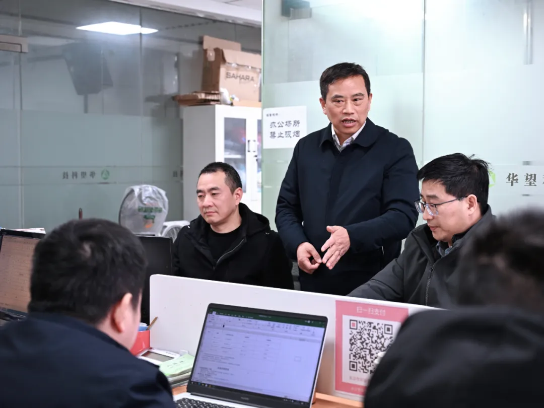 刘胜祥与员工探讨技术开发，持续推动科技创新。