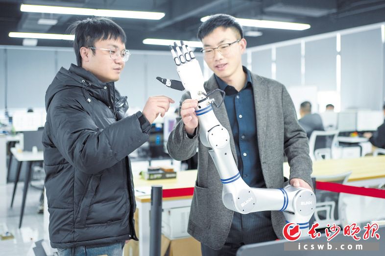 李艳斌（右）和团队成员正在调试人形七轴手臂产品。长沙晚报全媒体记者 何文瑞 摄